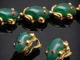 a group of green jade and gold jewelry on a black surface