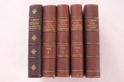 quatre vieux livres posés l'un sur l'autre sur une surface blanche