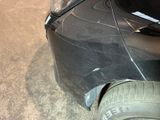 a black car that has a tire on the ground