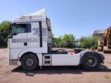 a white truck parked in a lot with a bulldozer in the background