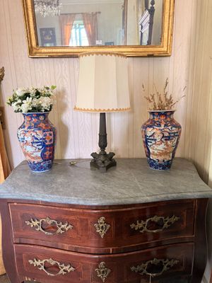 two vases sitting on top of a dresser next to a mirror