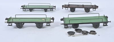 quatre types différents de wagons de train miniature posés sur une surface blanche