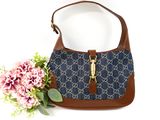 blue and brown guccissi handbag with flowers on a white background