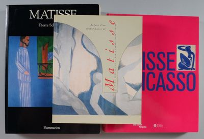 trois livres sont empilés sur une table