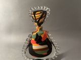 une petite figurine représentant une femme vêtue d'une robe colorée