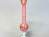 pink glass vase with gold trim on a white pedestal