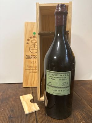 une bouteille de vin posée sur une table à côté d'une caisse en bois