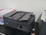 a printer sitting on top of a desk in front of a window