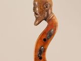 a close up of a violin with a head on the back