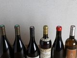 several bottles of wine are lined up on a wooden table