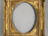 a gold picture frame with a white background and a white wall