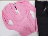 a pink sweater and black pants sitting on a table