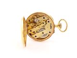 a close up of a pocket watch on a white surface