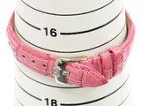 a close up of a pink leather bracelet on a stack of mugs