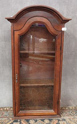 une vitrine ancienne en bois, dotée de portes vitrées et d'étagères