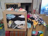 a box full of clothes sitting on top of a pile of luggage