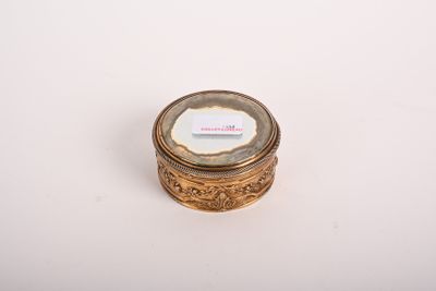 une boîte ancienne en or et en verre, sur laquelle est apposée une étiquette