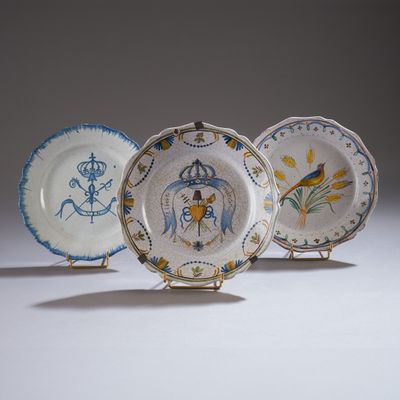 trois assiettes ornées de motifs, posées sur une surface blanche