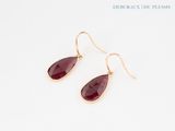 a pair of red stone earrings on a white background