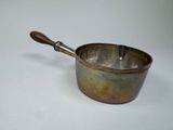 an old metal saucepan with a wooden handle on a white surface