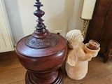 a wooden table with a vase on top of it next to a bed