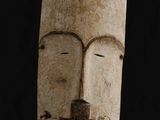 un masque en bois surmonté d'un nid d'oiseau