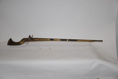 an old gun with a wooden handle on a white surface