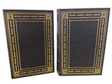 a pair of black and gold books with gold trimming