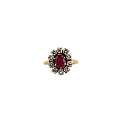 gros plan d'une bague en or avec une pierre rouge