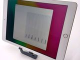 tablet computer sitting on top of a white table with a colorful screen