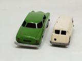 two toy cars sitting next to each other on a white surface
