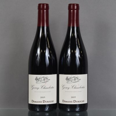two bottles of red wine sitting on top of a glass table