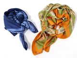 deux écharpes posées sur une surface blanche : l'une est orange et l'autre est bleue