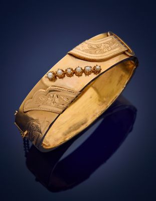 a close up of a gold bracelet on a blue background