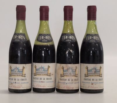 four bottles of wine are lined up on a white surface