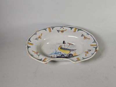 un petit bol orné d'un bateau, posé sur une table