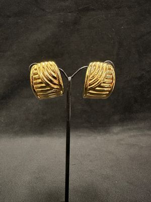 pair of gold plated earrings on a stand against a black background
