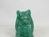 an image of a green ceramic pig figurine on a white background