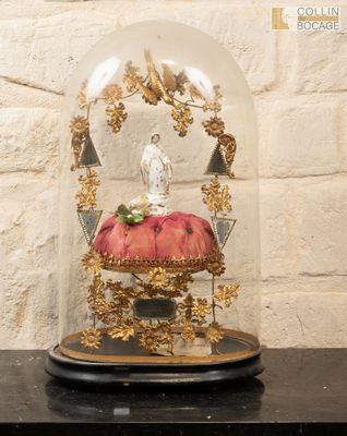 a glass dome with a figurine inside of it on a table