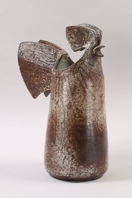 a brown vase with an angel on it on a white background