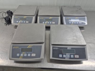 quatre balances électroniques posées sur une table dans une pièce