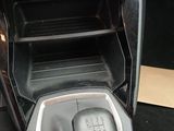 the interior of a car with a gear box and a shift button