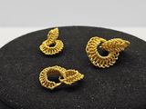 un gros plan sur une paire de boucles d'oreilles posées sur une boîte noire
