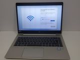 un ordinateur portable posé sur une table, avec le symbole du Wi-Fi affiché à l'écran