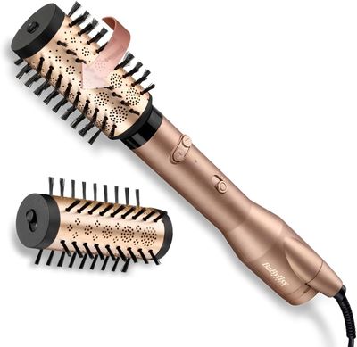 un gros plan d'un sèche-cheveux et d'une brosse posés sur une surface blanche