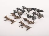 de nombreuses petites figurines de chiens en bronze posées sur une surface blanche