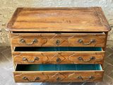 a small wooden chest of drawers on a tiled floor