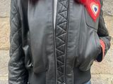 woman wearing a black leather jacket with red fur collar and jeans