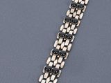 a close up of a black and white bracelet on a gray surface