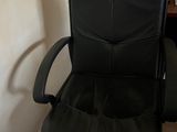 une chaise de bureau en cuir noir dans un coin de la pièce